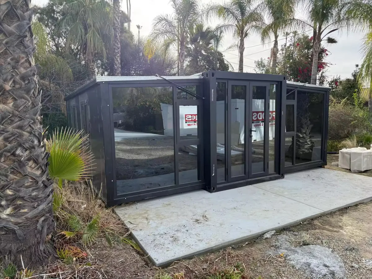 A finished black modular ADU unit on site in California